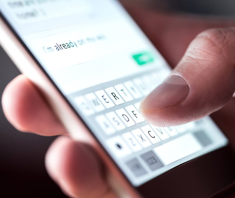 A person cautiously responding to a text, wondering if they can get hacked.