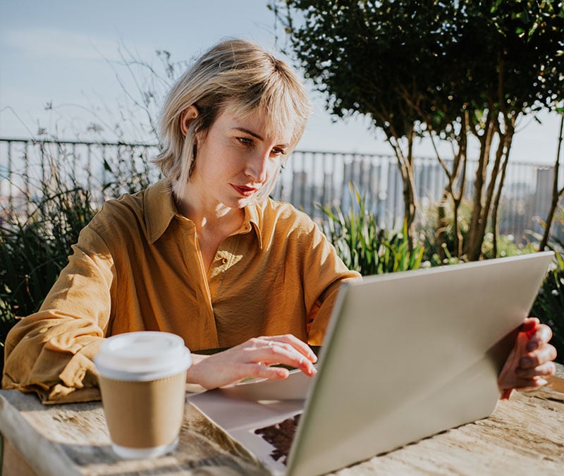 A person on their laptop, trying to identify a Norton email scam.