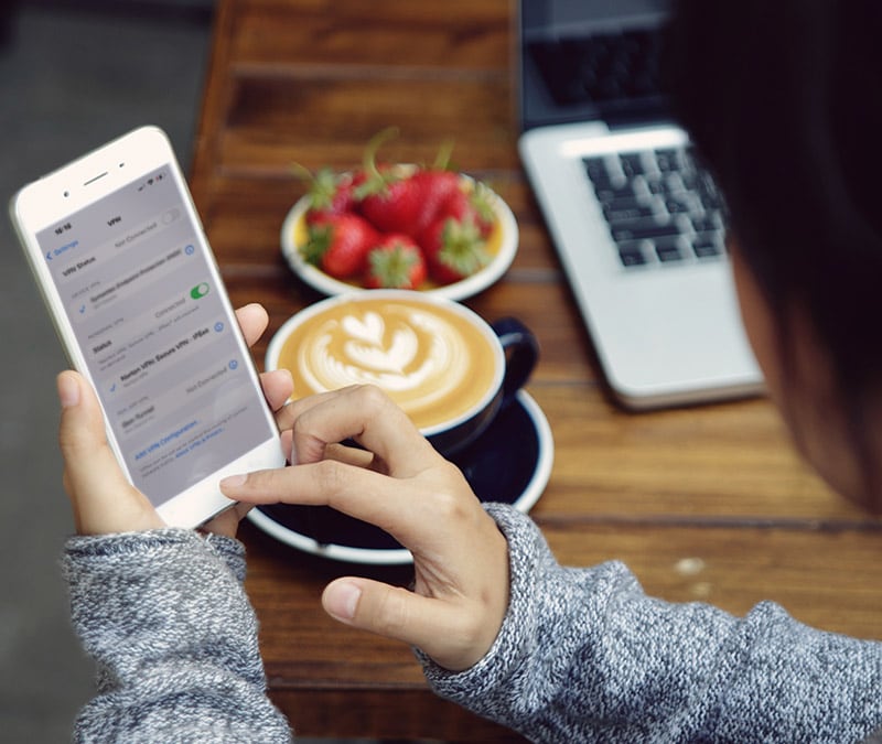 A person at a café turning off the VPN on her phone.