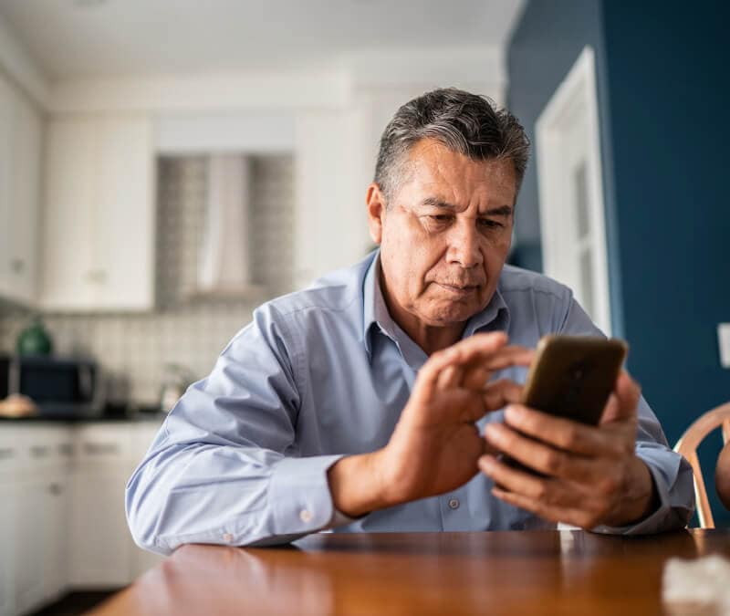 A man dials a number on his smartphone to check if his phone is hacked.