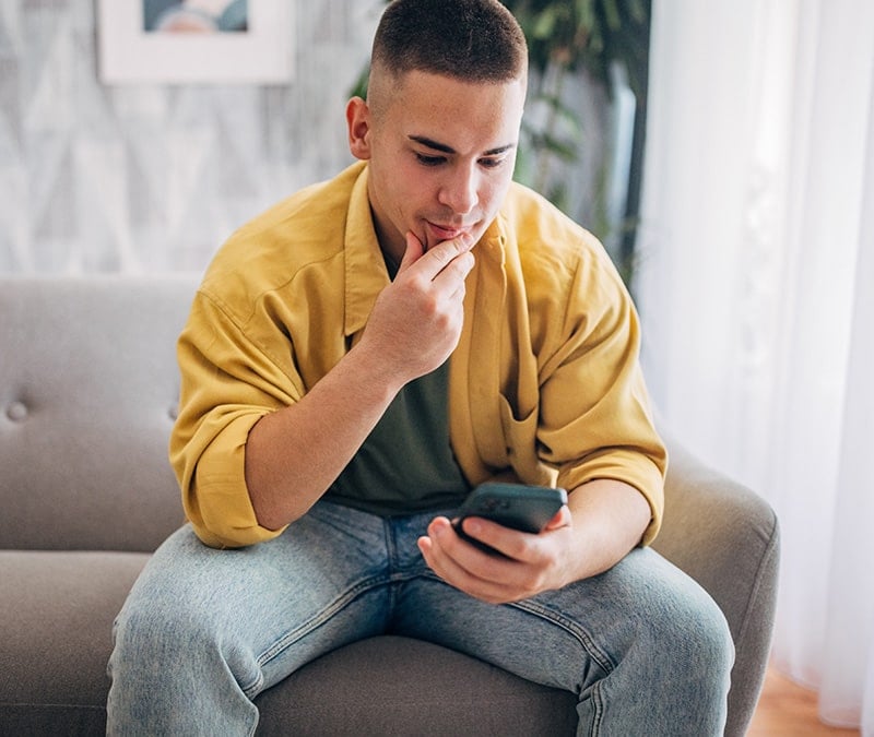 A man looks up online scams after receiving a suspicious email.