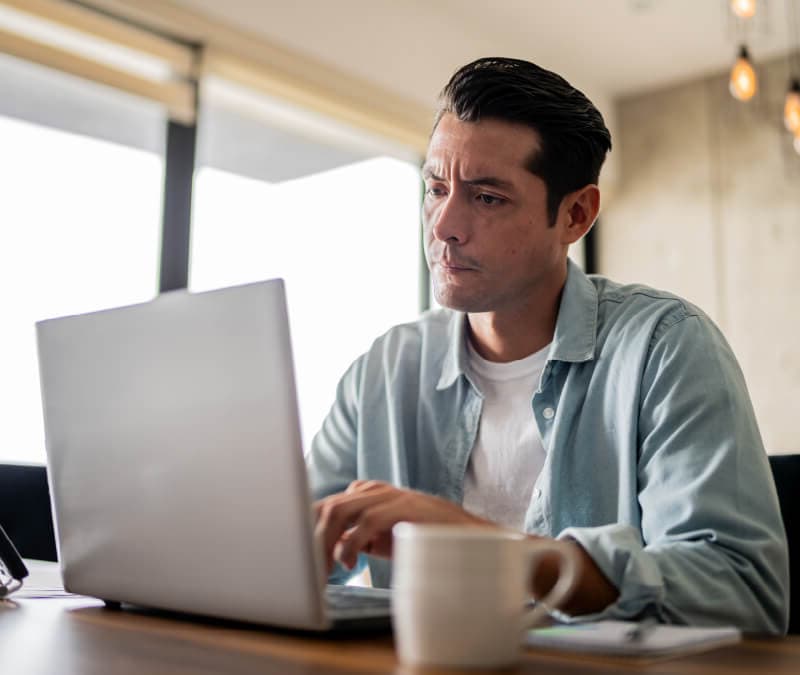 A concerned person looks at their laptop, wondering what type of malware they have.