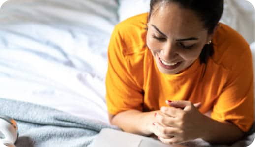 Woman lying on bed using a Laptop.