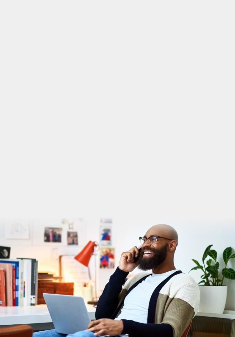 Man working on laptop using mobile